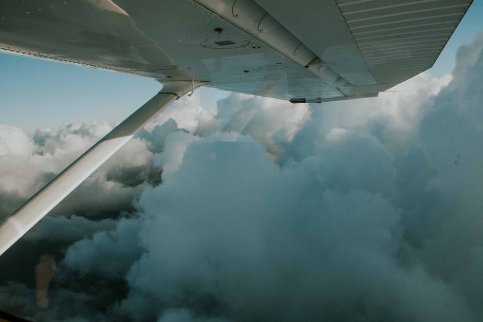 A serene view of dense clouds from an airplane wing, capturing the essence of flight and exploration.